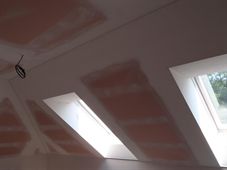 Sádrokartonový podhled se střešními okny ve fázi tmelení spár