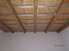 Dřevěný trámový strop nad omítnutými stěnami