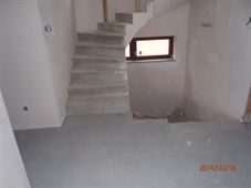 Omítnutý interiér se schodištěm a malým oknem
