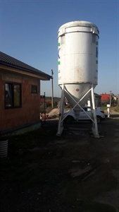 Exteriér: bílé válcové mixovací silo u domu