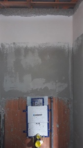 Omítnutá místnost s instalačním boxem na cihlové zdi