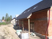 Dům s cihlovou fasádou a částečně omítnutou verandou
