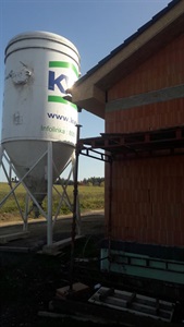 Exteriér: mixovací silo značky KVK u rozestavěného domu s lešením